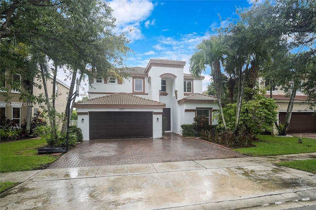 mediterranean / spanish-style house featuring a garage and a front lawn