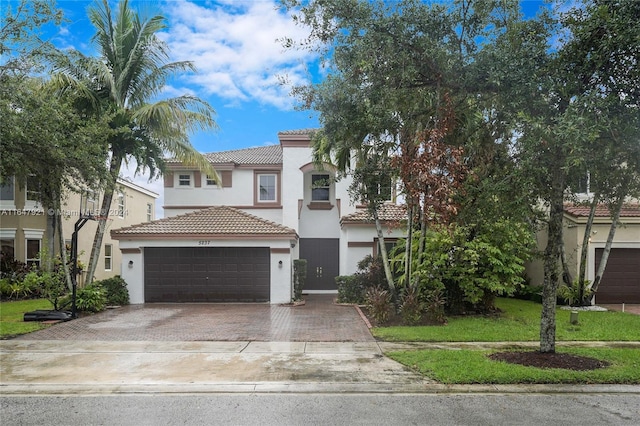 mediterranean / spanish house with a garage and a front lawn