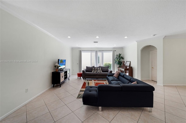 living room with a textured ceiling, crown molding, and light tile patterned floors