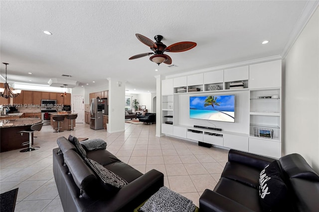 living room with light tile patterned flooring, ceiling fan with notable chandelier, crown molding, and a textured ceiling