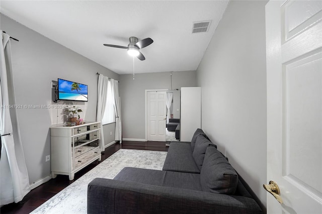 living room featuring ceiling fan and dark hardwood / wood-style flooring