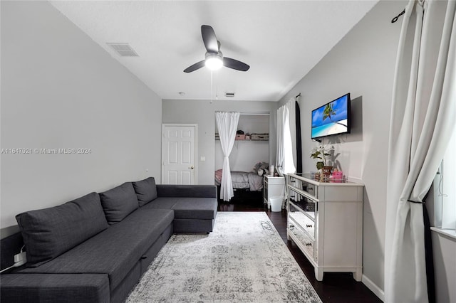 living room featuring dark wood-type flooring and ceiling fan