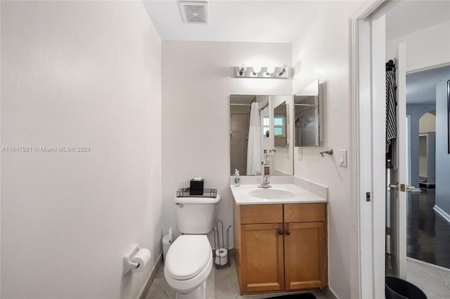 bathroom featuring tile patterned flooring, a shower with curtain, vanity, and toilet