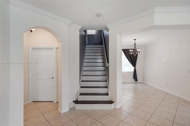 stairway featuring a notable chandelier, crown molding, and tile patterned floors