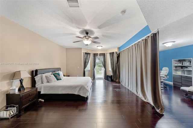 bedroom featuring ceiling fan, a textured ceiling, and dark hardwood / wood-style floors