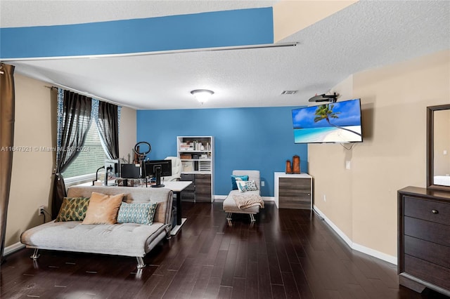 bedroom with a textured ceiling and dark hardwood / wood-style flooring