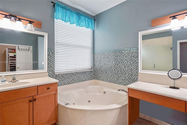 bathroom with tile walls, a tub to relax in, and vanity