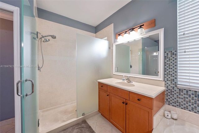 bathroom with tile walls, tile patterned flooring, a shower with shower door, and vanity