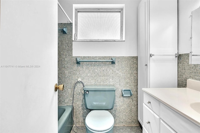 bathroom featuring tile patterned flooring, vanity, tile walls, and toilet