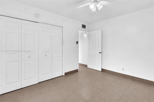 unfurnished bedroom featuring ceiling fan, light tile patterned floors, and a closet