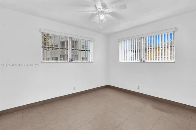 unfurnished room with light tile patterned floors, plenty of natural light, and ceiling fan