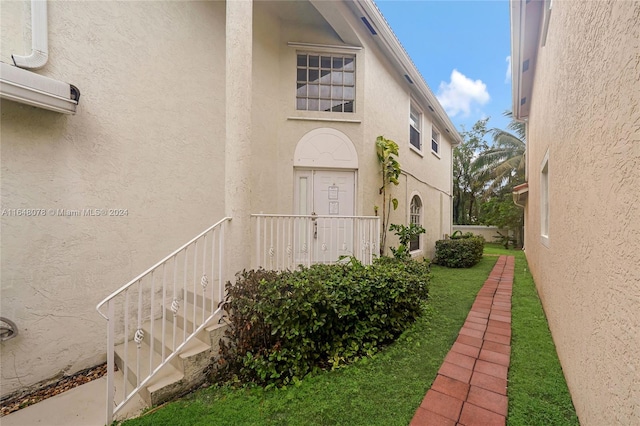 property entrance featuring a lawn