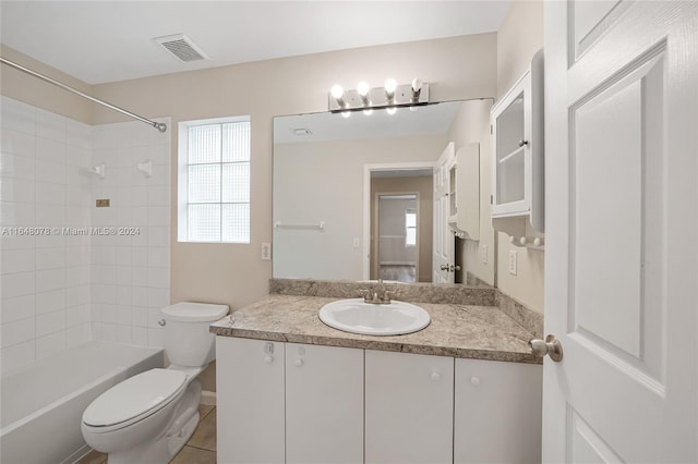 full bathroom featuring tile patterned floors, toilet, tiled shower / bath combo, and vanity