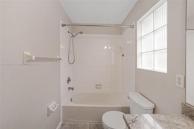 full bathroom with tiled shower / bath combo, vanity, toilet, and tile patterned flooring