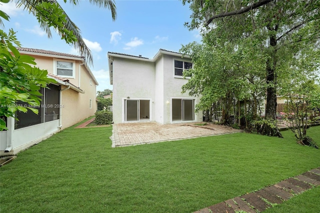 rear view of house featuring a yard and a patio