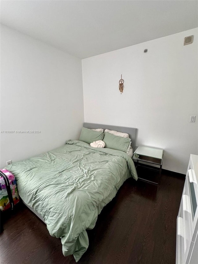 bedroom with dark hardwood / wood-style floors