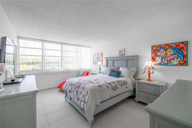 tiled bedroom with a textured ceiling and floor to ceiling windows