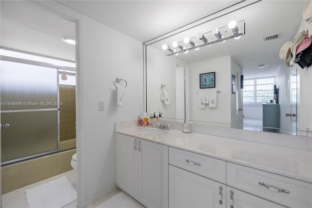 full bathroom featuring toilet, tile patterned floors, shower / bath combination with glass door, and vanity