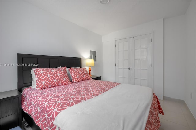 tiled bedroom with a closet and electric panel