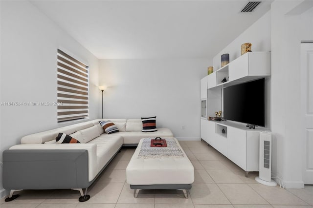 living area with baseboards, visible vents, and light tile patterned floors