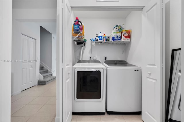 laundry area featuring washing machine and dryer and light tile patterned flooring