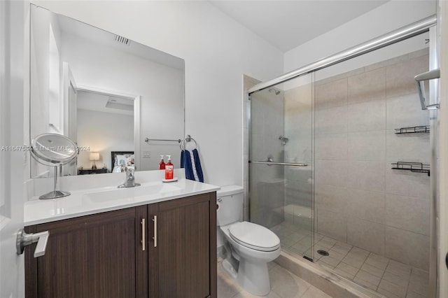 bathroom with an enclosed shower, toilet, vanity, and tile patterned floors