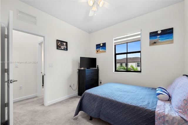 carpeted bedroom featuring baseboards, a ceiling fan, and visible vents