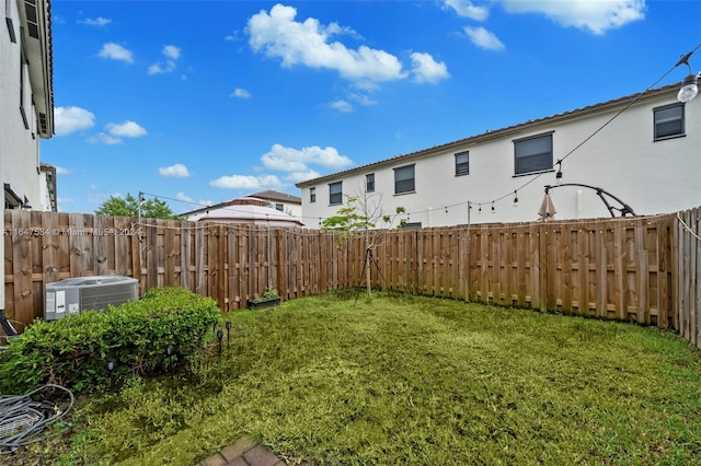view of yard featuring a fenced backyard and central AC unit