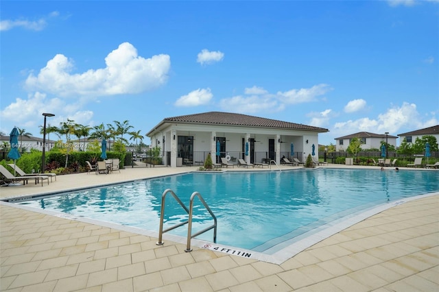 pool featuring fence and a patio area