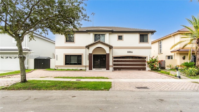 8886 NW 187th St, Miami, FL 33018 - view of front of property with a tiled roof, decorative driveway, a garage, and stucco siding