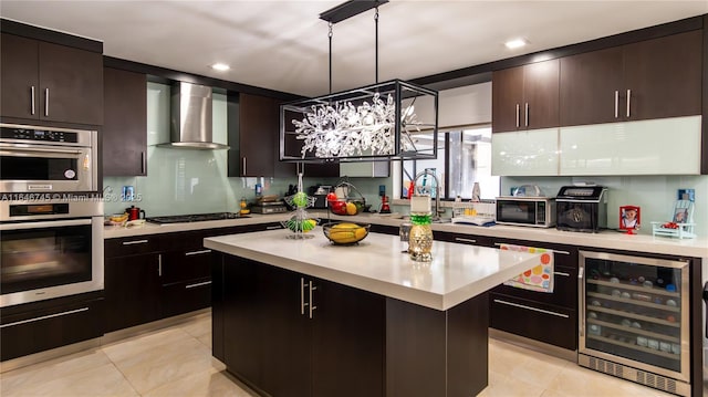 8886 NW 187th St, Miami, FL 33018 - kitchen featuring black gas cooktop, wall chimney exhaust hood, light countertops, double oven, and beverage cooler