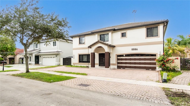 8886 NW 187th St, Miami, FL 33018 - view of front facade featuring a tile roof, an attached garage, decorative driveway, and stucco siding