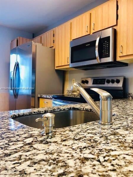 kitchen featuring appliances with stainless steel finishes and light stone countertops