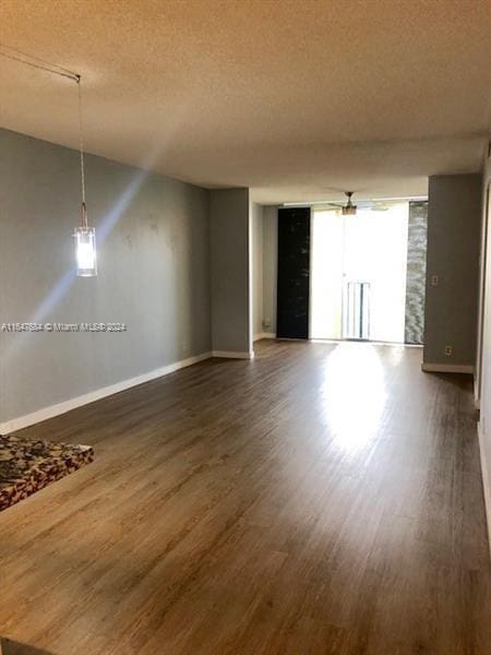 unfurnished room featuring a textured ceiling and dark hardwood / wood-style floors