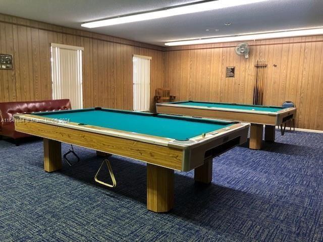 rec room with billiards, wood walls, and dark carpet