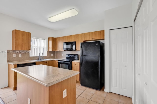 kitchen with tasteful backsplash, light tile patterned floors, sink, black appliances, and a center island