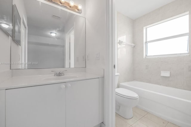 full bathroom with toilet, tiled shower / bath, vanity, and tile patterned floors