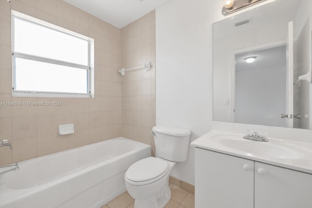 full bathroom with tiled shower / bath, toilet, tile patterned floors, and vanity