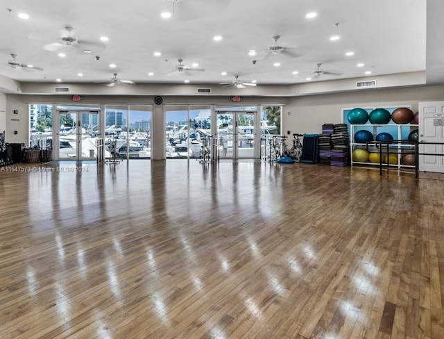 exercise room featuring plenty of natural light, hardwood / wood-style flooring, french doors, and ceiling fan