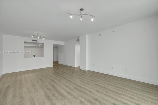 unfurnished room featuring light wood-type flooring and rail lighting