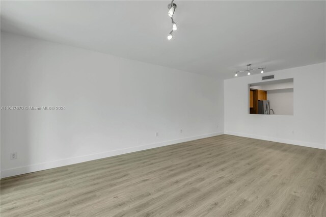 unfurnished living room with light hardwood / wood-style flooring and track lighting