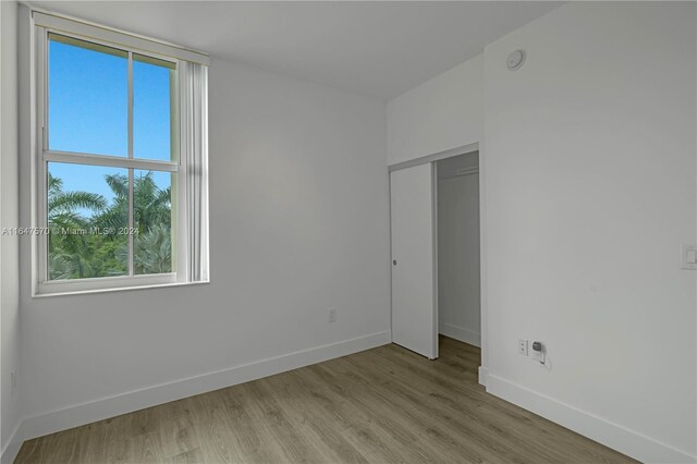 unfurnished bedroom with a closet and light hardwood / wood-style floors