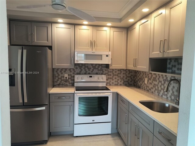 kitchen with ceiling fan, decorative backsplash, sink, and white appliances