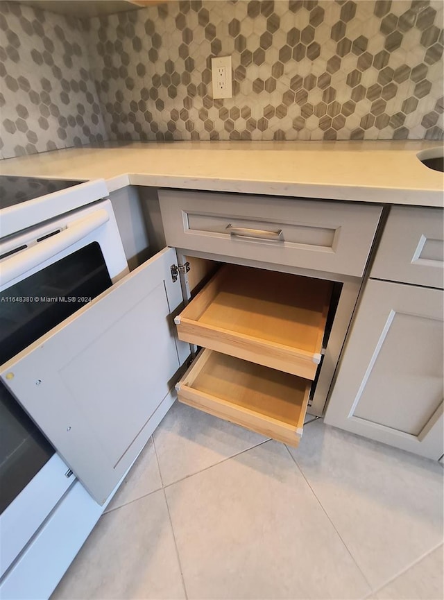 room details featuring white electric stove and light tile patterned flooring