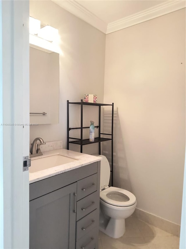 bathroom featuring tile patterned flooring, crown molding, vanity, and toilet