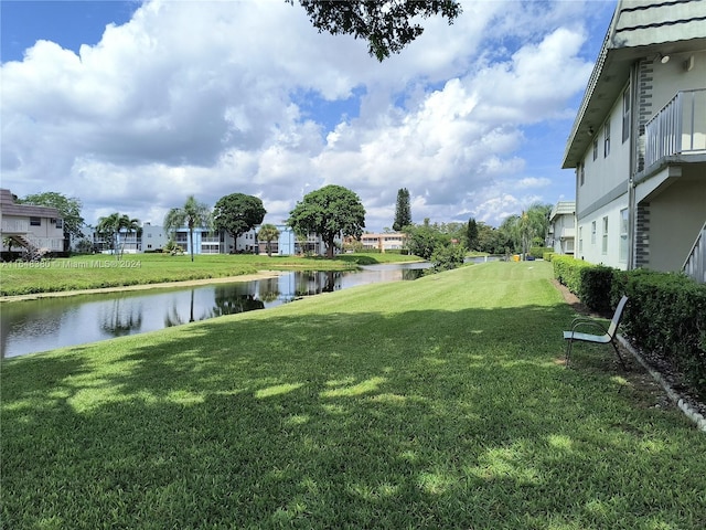 view of yard with a balcony and a water view