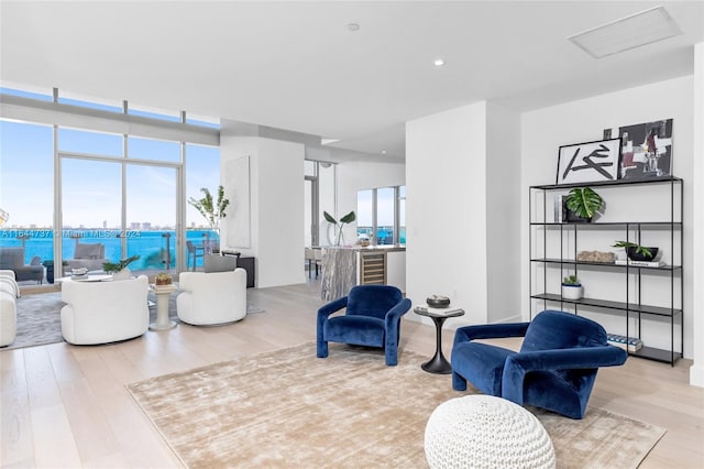 living room with visible vents, recessed lighting, a water view, and wood finished floors