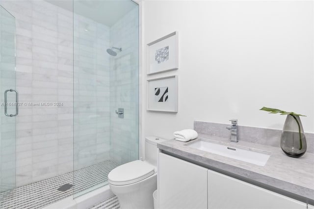 bathroom featuring vanity, toilet, and a stall shower