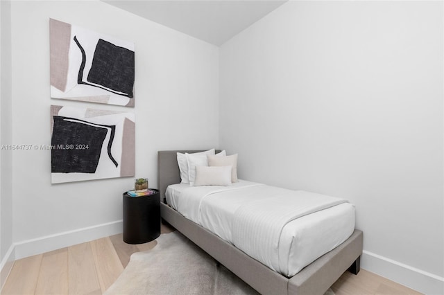 bedroom featuring baseboards and wood finished floors