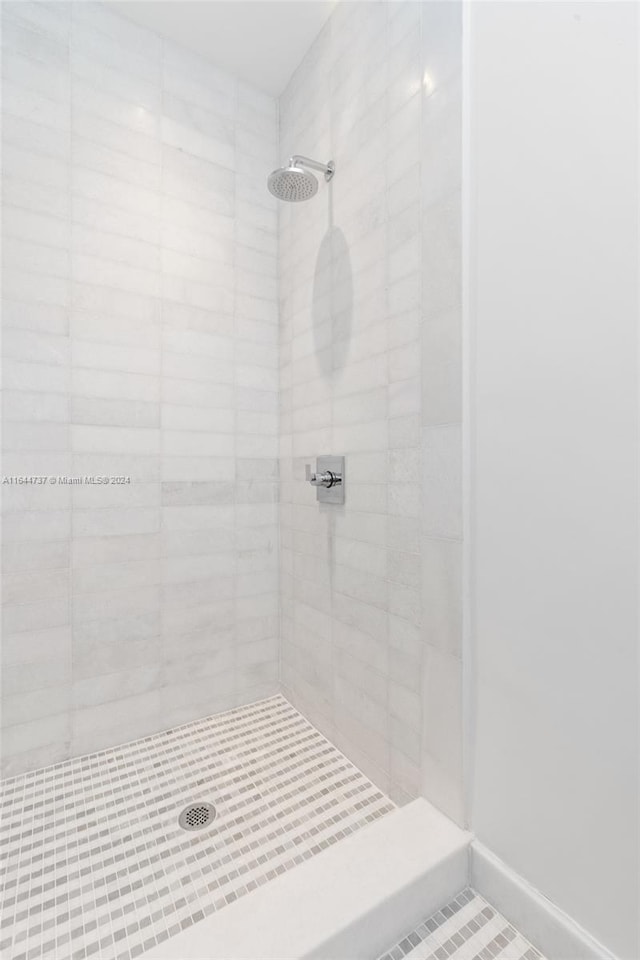 bathroom with tile patterned flooring and a tile shower